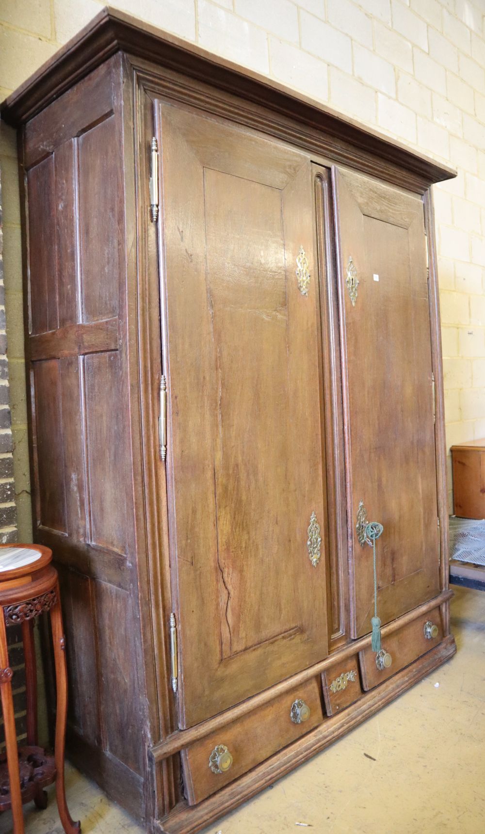 An 18th century Normandy oak two door armoire with brass escutcheons and buttressed hinges, W.178cm, H.218cm